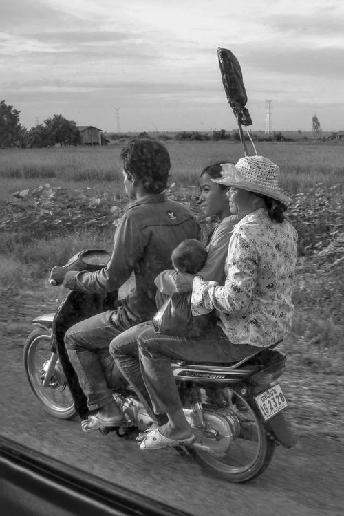 Scooter carrying 3 adults and a baby with an IV Bag on a pole on Route 5. 