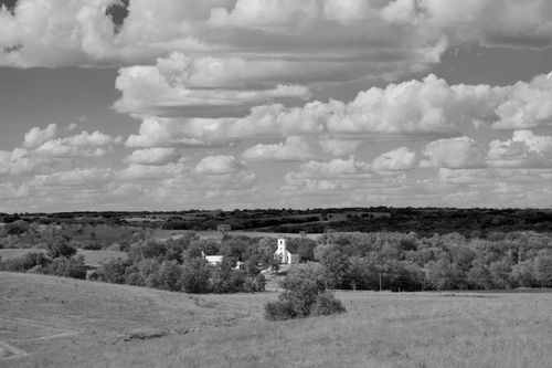 Low rolling hills and puffy white clouds with Immanuel Lutheran Church sticking up out of the center.