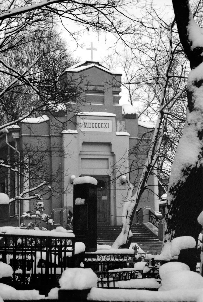 Holy Trinity covered in snow, surrounded by cemetery fencing.