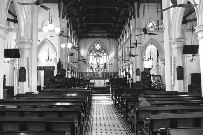 Inside St. John's Cathedral, with a few people sitting quietly in the pews.