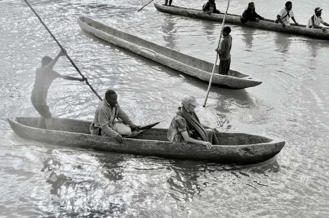 Three dugout canoes crossing a stream. 