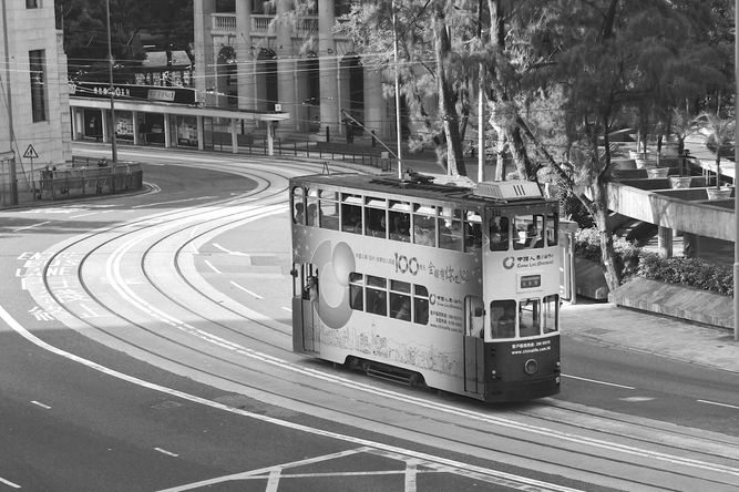 A double decker tram winding through the streets of downtown Hong Kong.