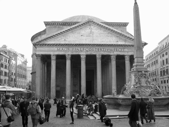 Photo of the Pantheon entrance with tourists walking in front. 